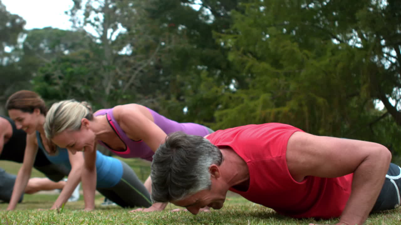 grupo de personas atléticas haciendo flexiones en el parque