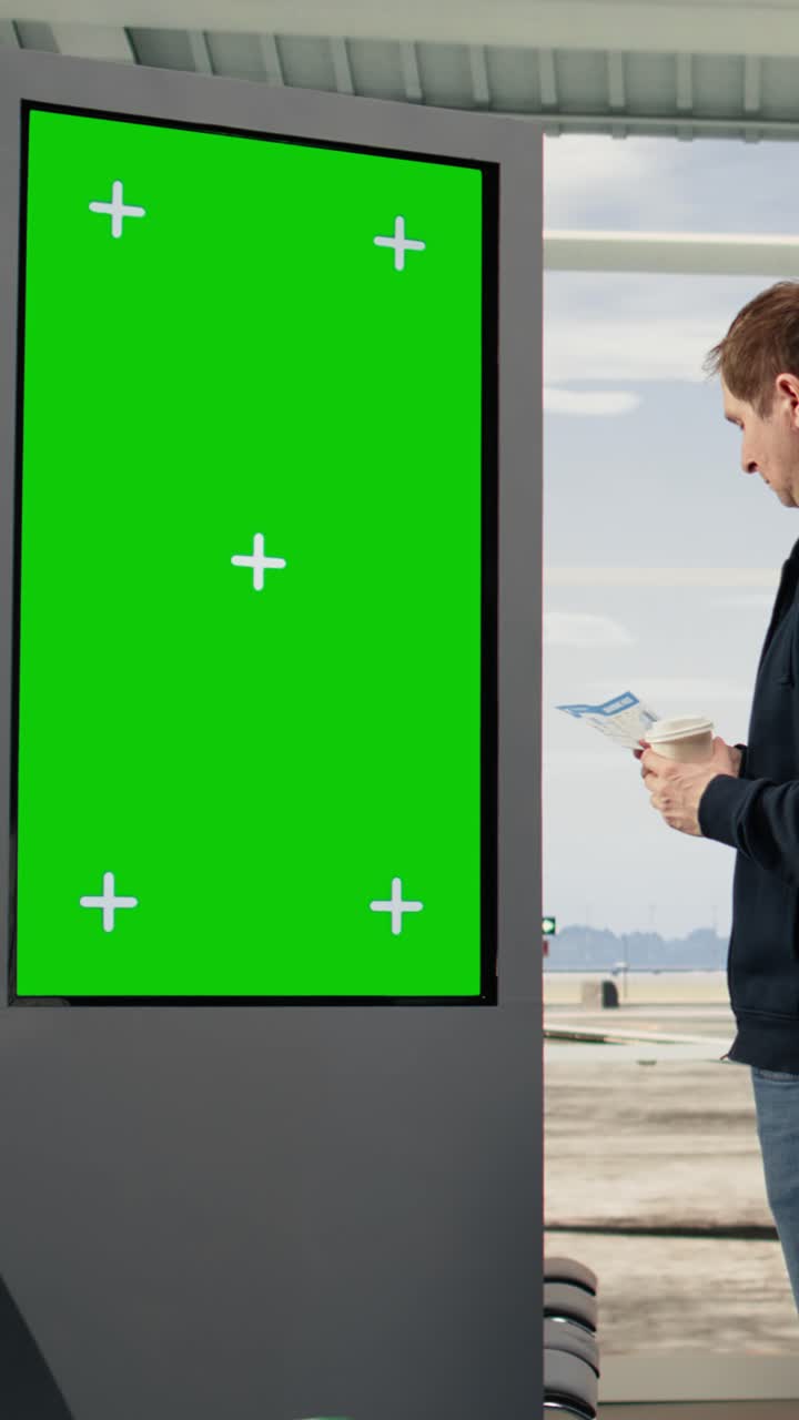 Vertical Video Green screen display with traveler observing board panel in airport waiting area