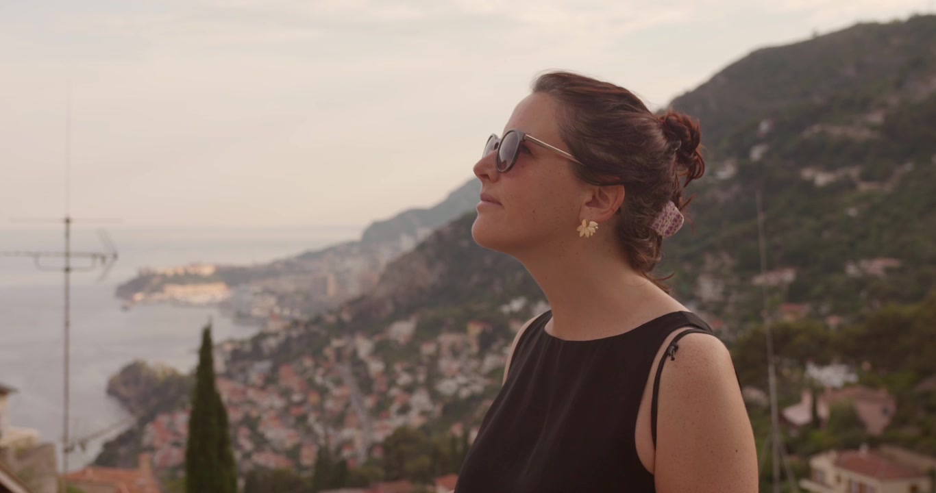 Woman in sunglasses enjoying panoramic view over French Riviera coastal town