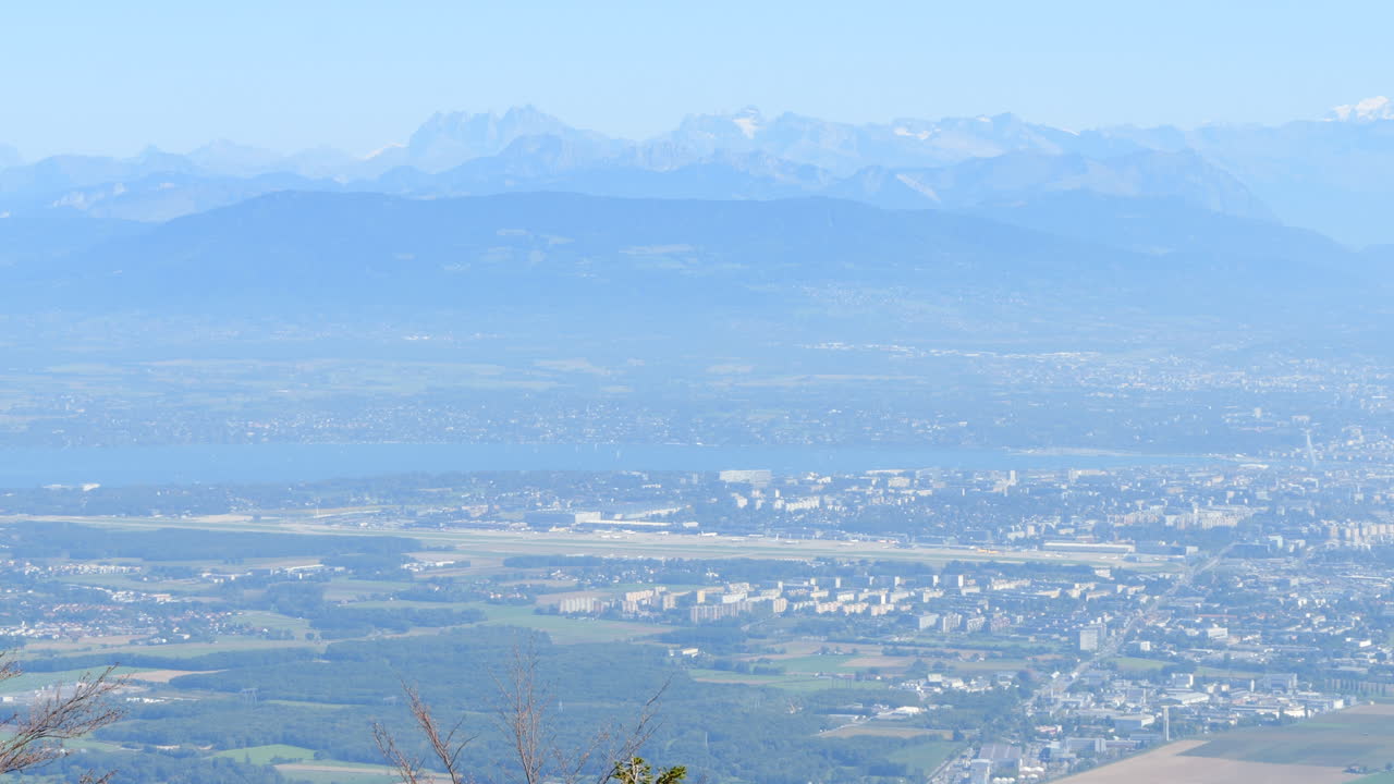 Distant View of Geneva Airport at the Lake with Alps in Background