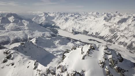 drone revealing shot above snowy alpine summits in winter 4k