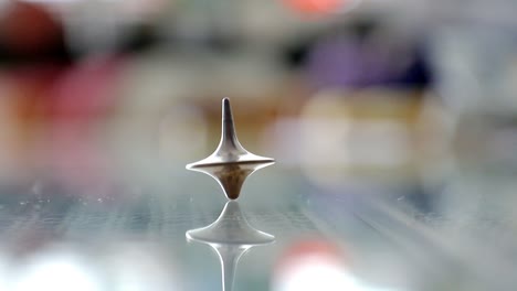 whirligig spinning on a glass table in slow motion