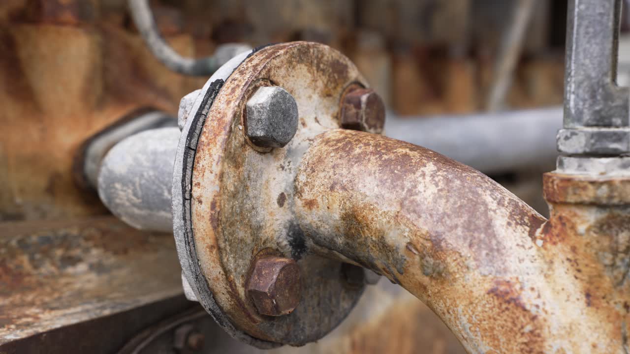 Rusten industriel motorrørforbindelse, der viser korrosion og alder på metaloverfladen
