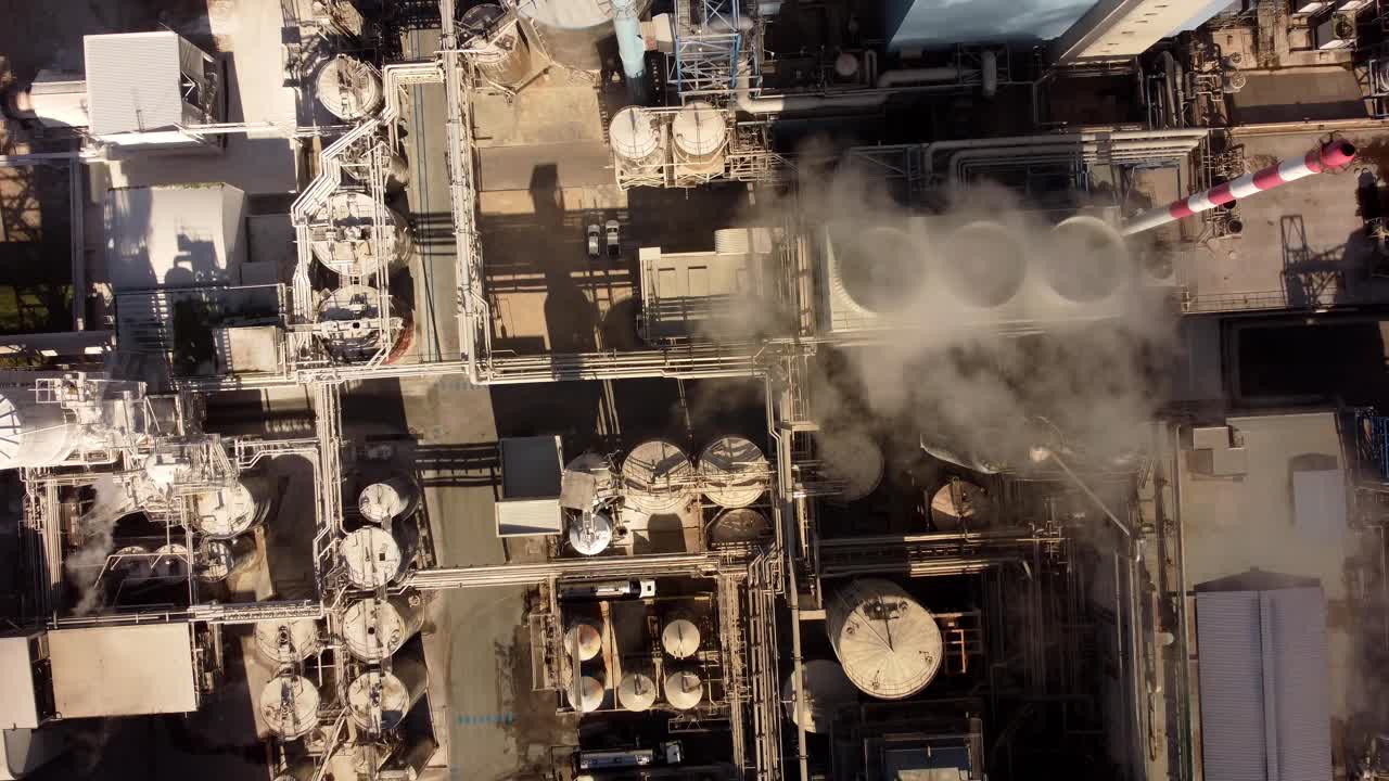 vista aérea de pájaro del humo blanco del sitio industrial con chimenea y tuberías smog contaminación peligrosa