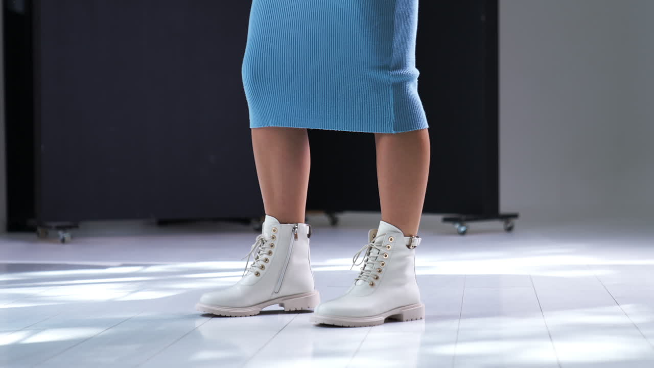 Woman in Light Blue Dress and White Boots