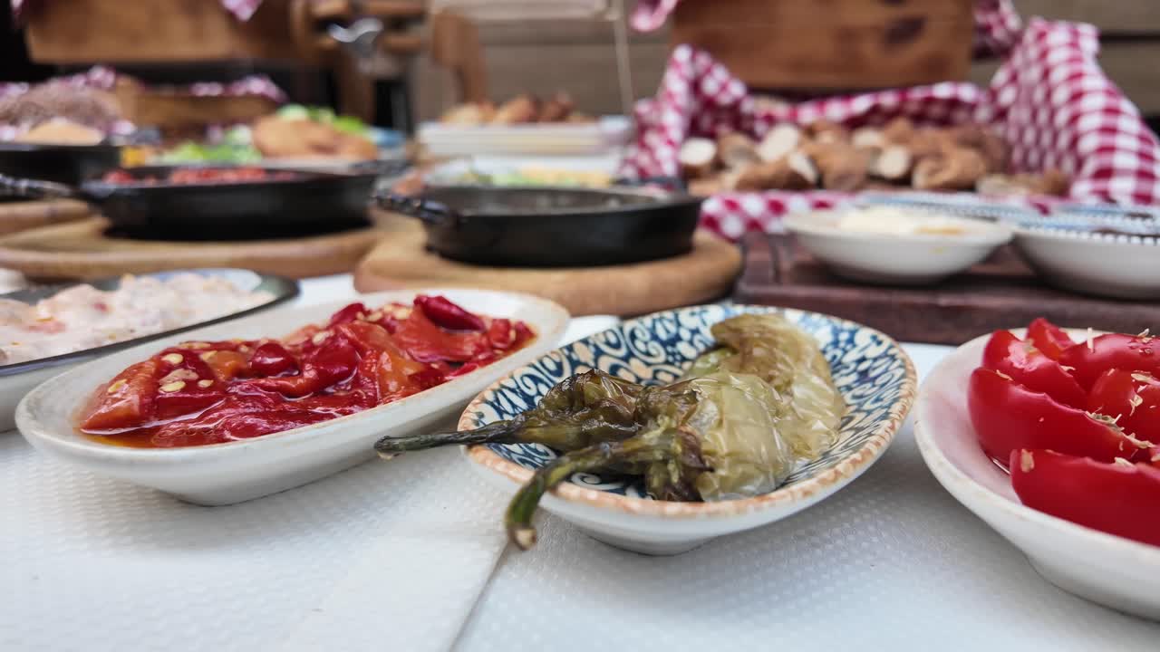 Food buffet with pickled peppers, tomatoes and bread