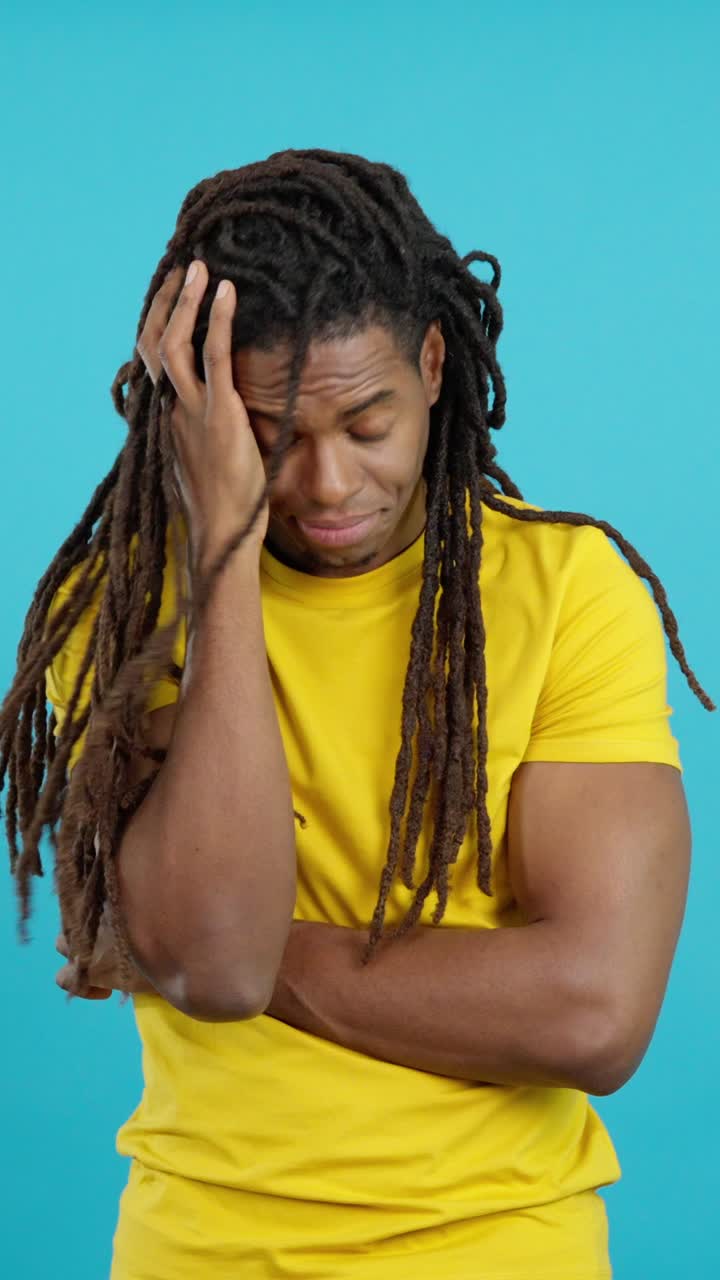 Man with dreadlocks in yellow t-shirt