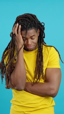 Man with dreadlocks in yellow t-shirt