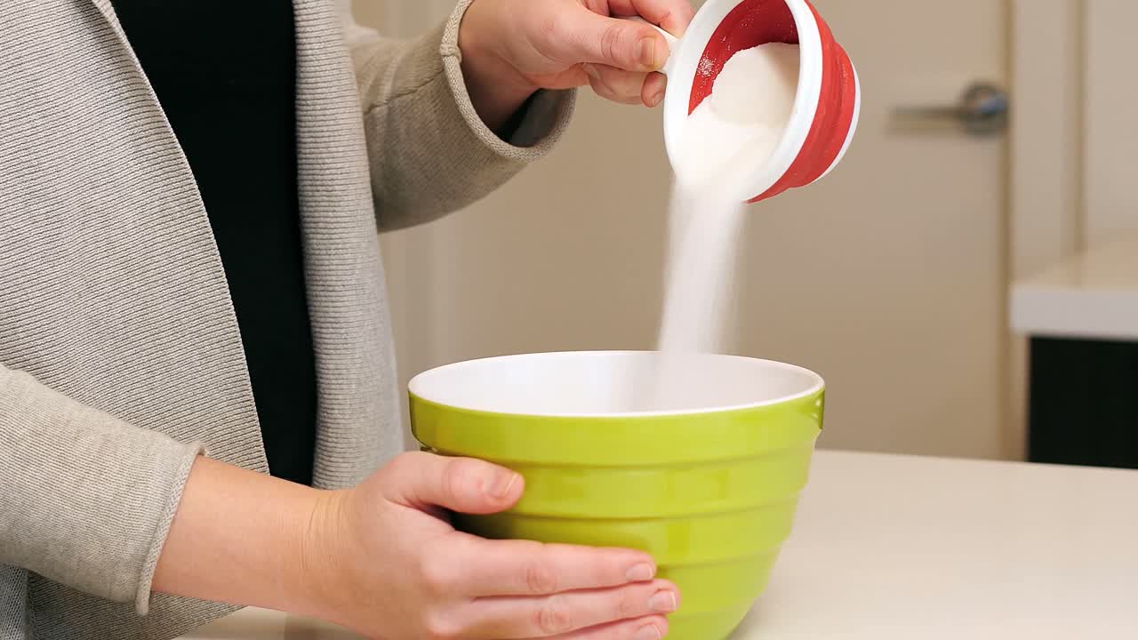 mujer añadiendo ingredientes al plato para hornear