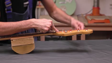 putting new guitar string through the tuning machine post