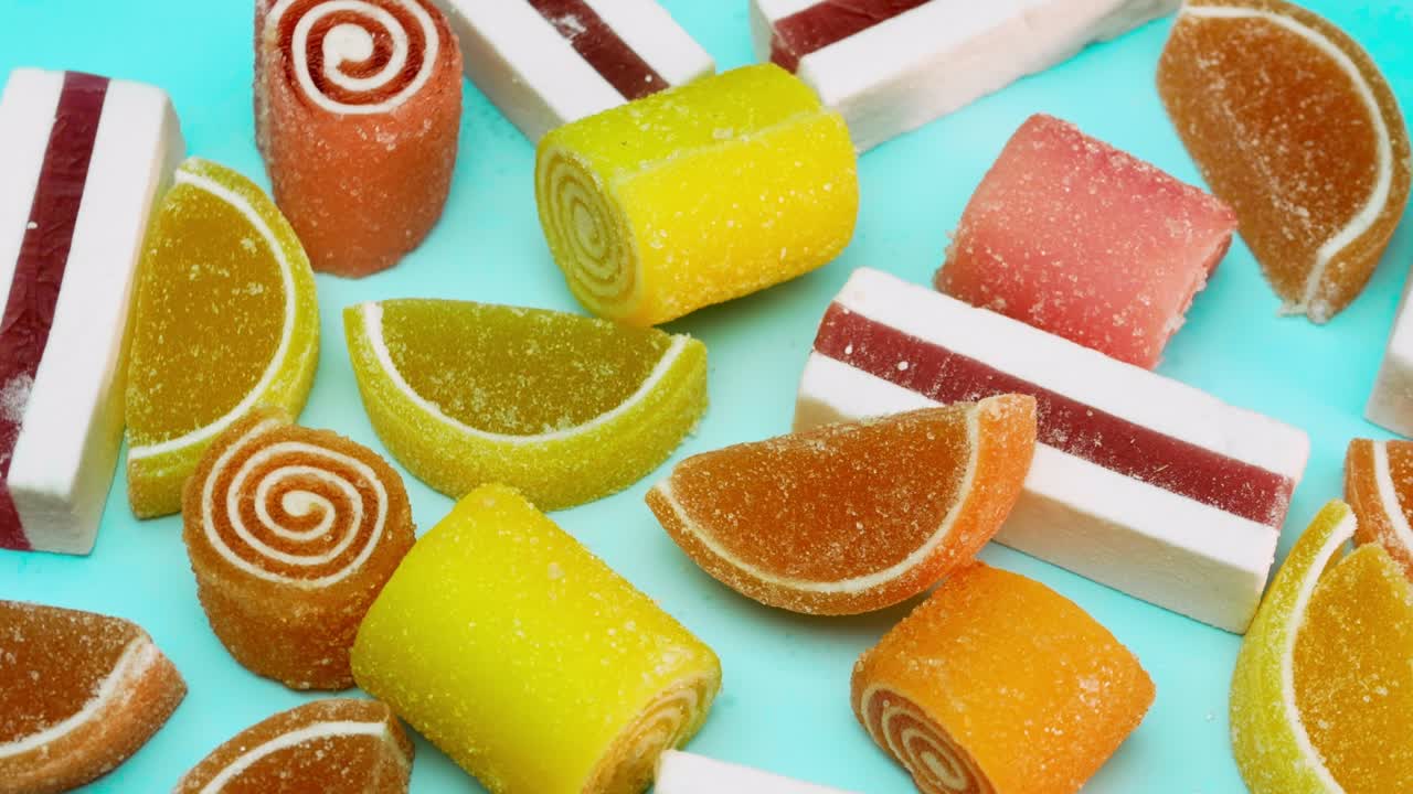Blanding av flerfarget vingummi på en blå bakgrunn. Et sett med gelégodteri.