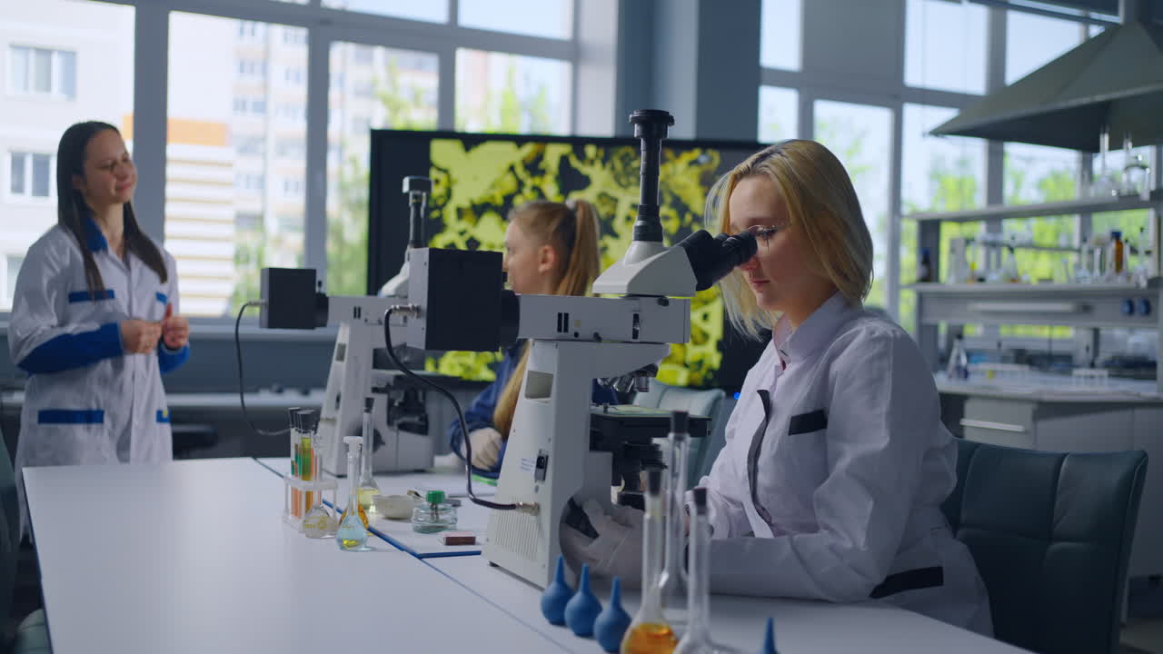 студенты, работающие в лабораторных условиях с использованием микроскопов