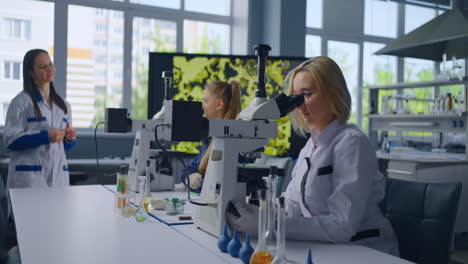 estudiantes que trabajan en un entorno de laboratorio usando microscopios