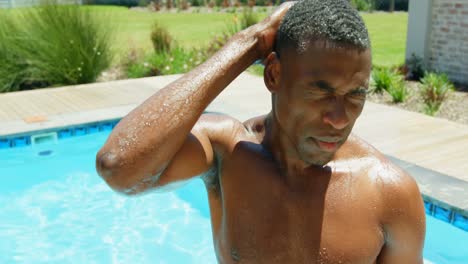 front view of young black man standing in the swimming pool at resort 4k