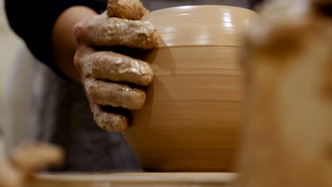 potter is making clay pot on the potter's wheel