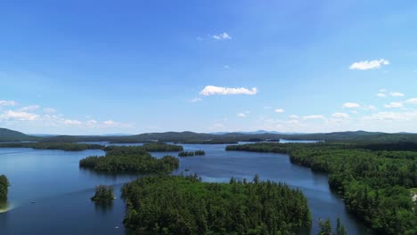 Drone-footage-of-serene-NH-White-Mountains-lake,-isolated-island-house,-and-natural-beauty