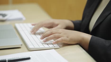 businesswoman hands typing on laptop computer keyboard for searching information,marketing research report in the office desk