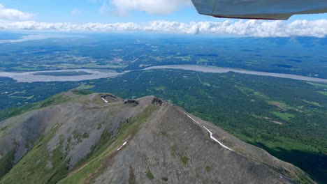 small airplane flight over a mountain ridge with the town of palmer alaska and the matanuska river in the distance