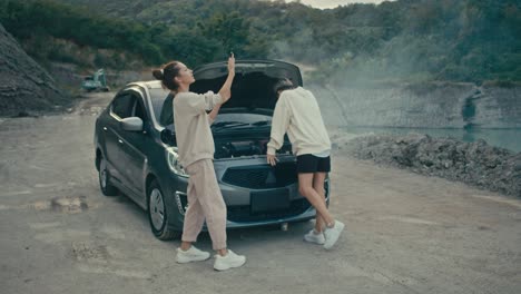 women dealing with a car breakdown in a scenic outdoor setting
