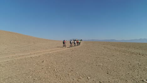 aerial footage of a group of bicycle riders riding on bike trails in the desert