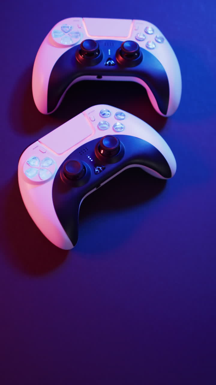 Vertical video of video game pads on purple neon background