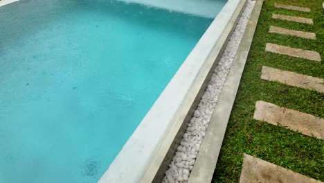 side of swimming pool rainfall rain water surface drops texture bright blue color