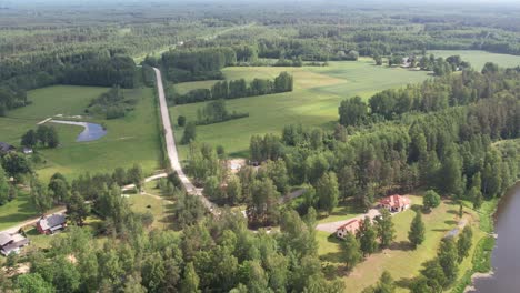 una vista de un dron de la aldea de brenguli, capturando su pintoresco encanto rural con casas esparcidas, campos verdes y densos bosques