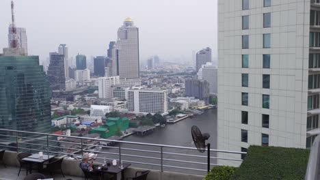 the impressive rooftop bar of hilton, with a beautiful skyline view of the impressive buildings of bangkok, the capital of thailand