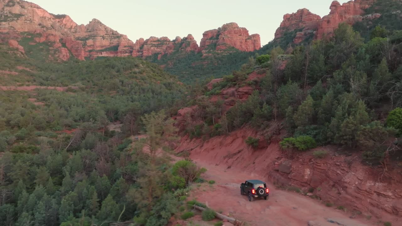 suv compacto de tracción en cuatro ruedas conduciendo por un camino accidentado a las colinas de piedra arenisca de sedona en arizona