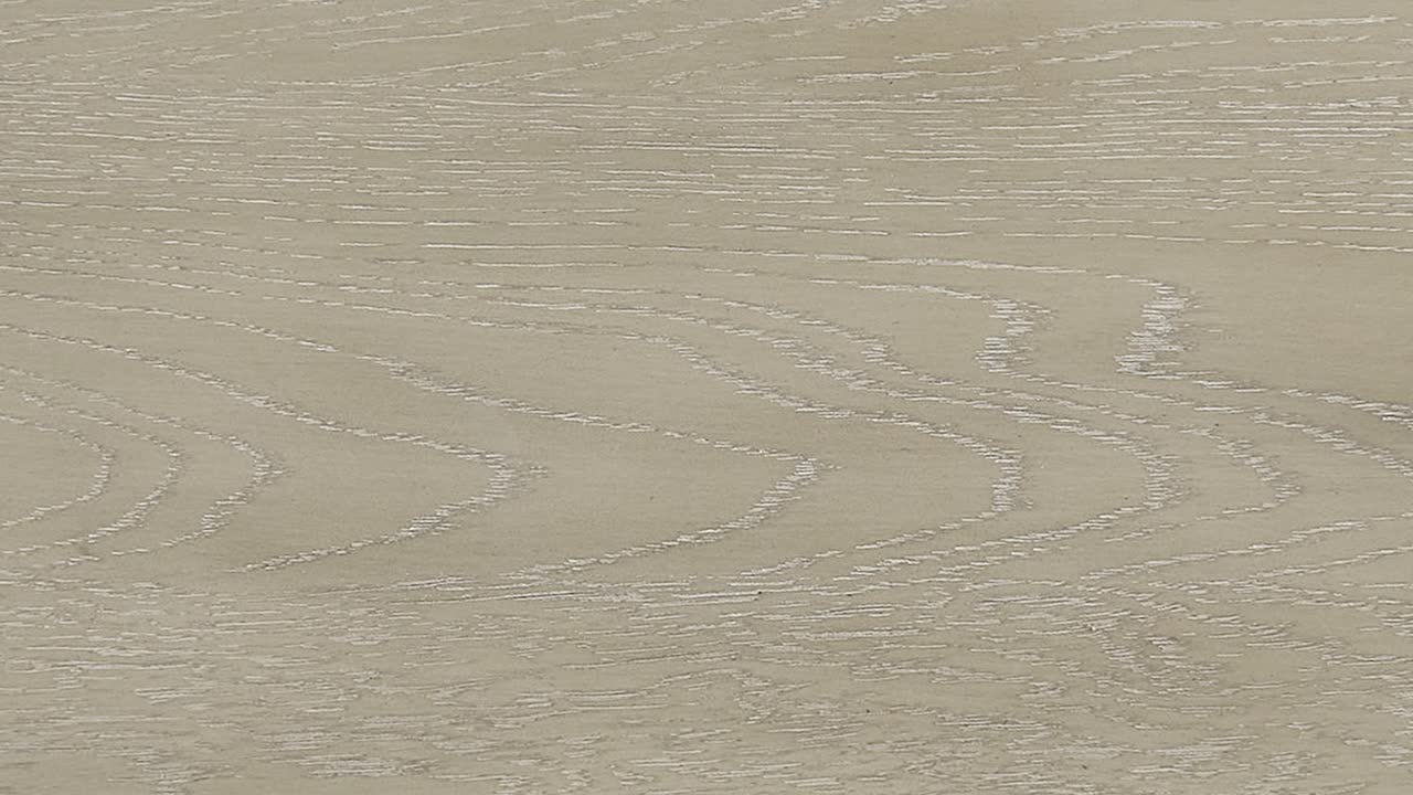 Camera sweeps over bright ash surface, revealing fine grain and subtle sheen