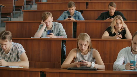 Grupo-Multiétnico-De-Estudiantes-Que-Utilizan-Teléfonos-Inteligentes-Durante-La-Conferencia.-Jóvenes-Que-Usan-Las-Redes-Sociales-Mientras-Estudian-En-La-Universidad.