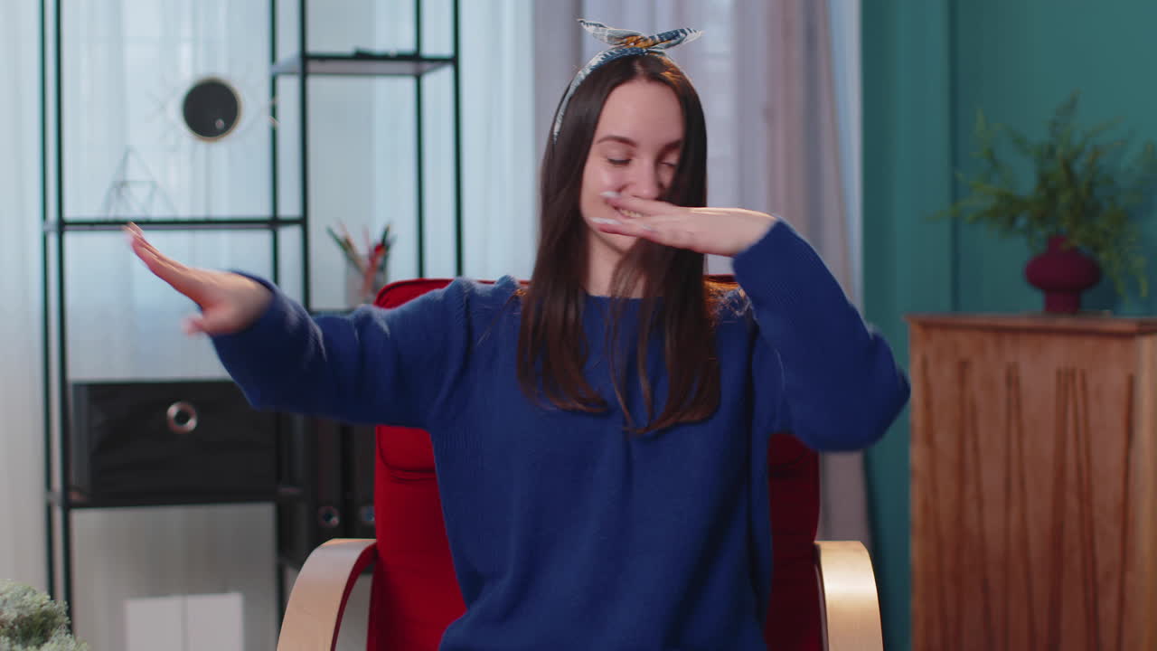 젊은 여성이 춤을 추고 리에 따라 움직이고, 손을 들고 댄스 제스처를 하고 있습니다.