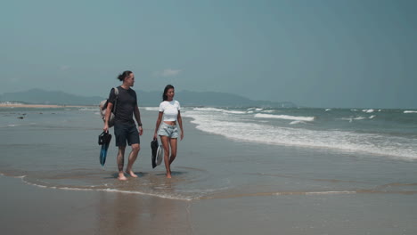 Una pareja caminando por la playa.
