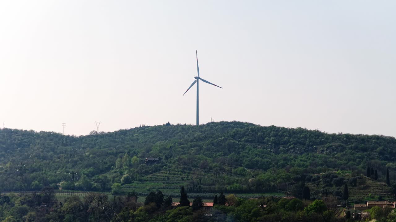 Wind turbine on green hill near Rivoli, Italy – aerial view