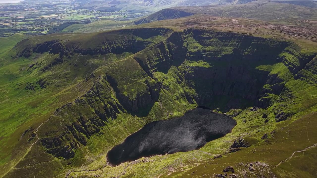Güzel güneşli bir günde Coumshingaun Gölü ve dramatik falezlerin destansı drone panoraması