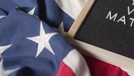 close up of sign reading your vote matters lying on us stars and stripes flag for american election 2024