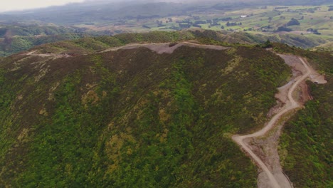 Rugged hill top road construction with vehicles moving