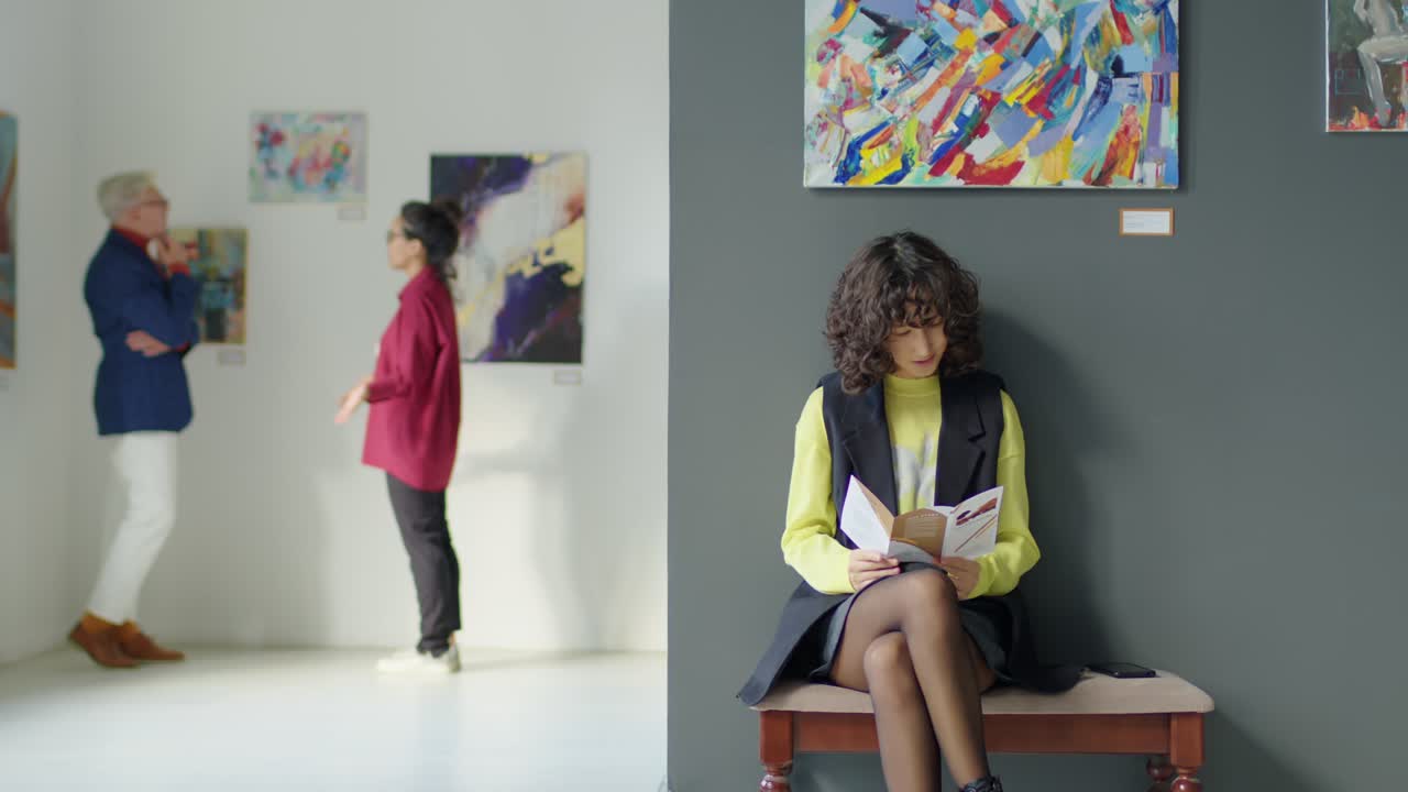 Female Visitor Reading Booklet in Art Gallery