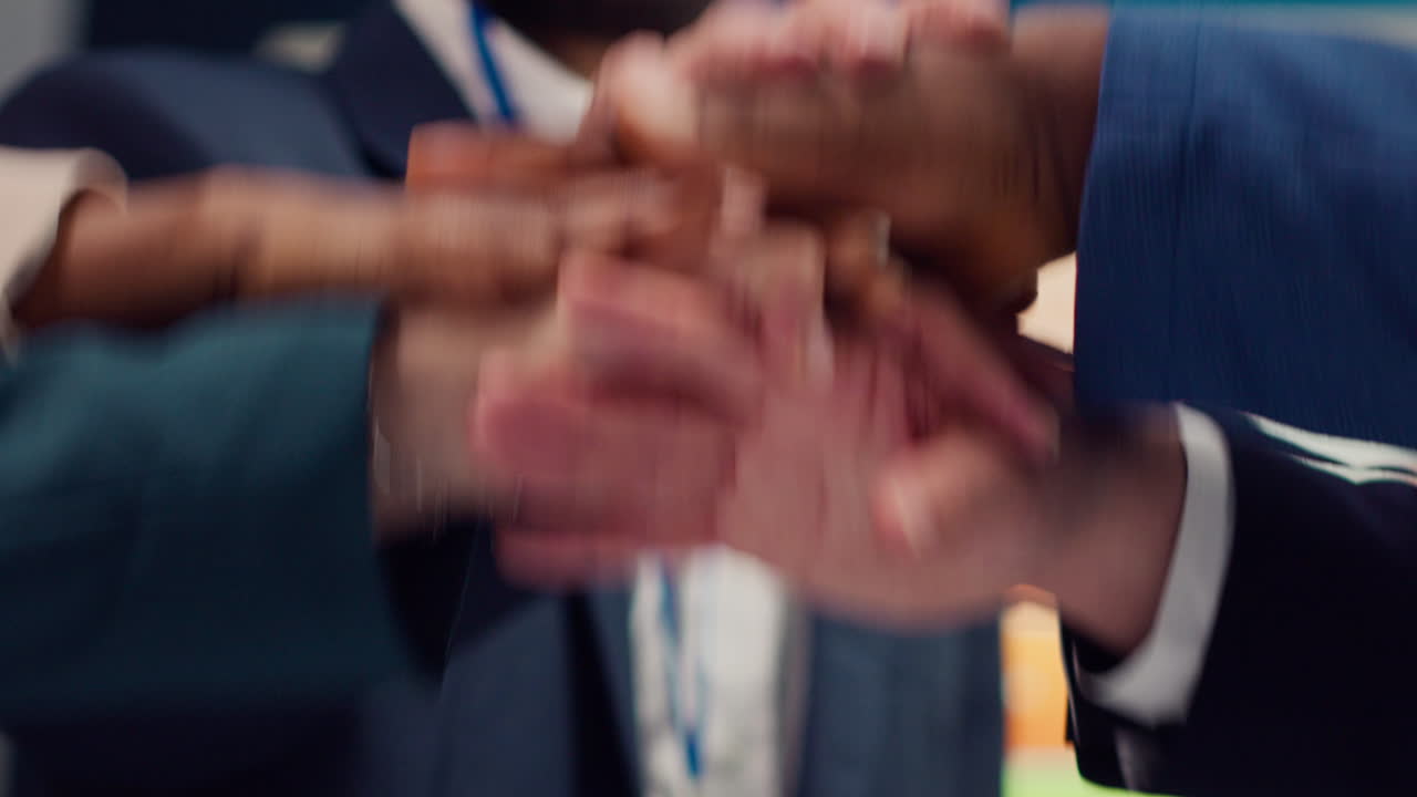 비즈니스 계열사들이 손을 잡고 축하하기 위해 손을 들어 올립니다.