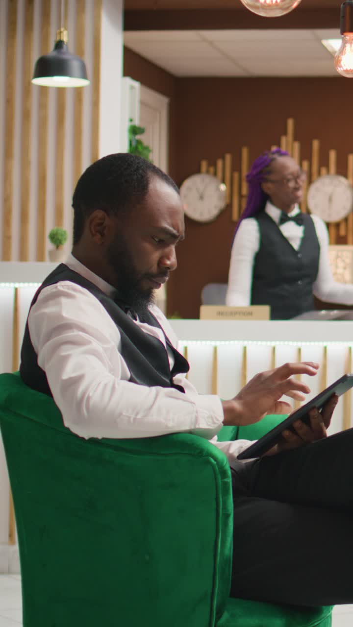 Vertical video African american staff making bookings