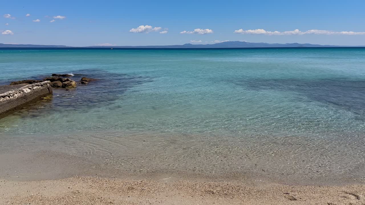Stunning beach scene in Halkidiki, Greece, with elegant sunbeds facing the crystal-clear turquoise sea. A perfect summer escape in the heart of the Aegean.