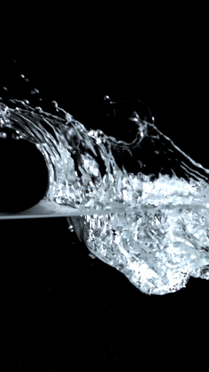 Schizzo d'acqua al rallentatore con bolle su sfondo nero