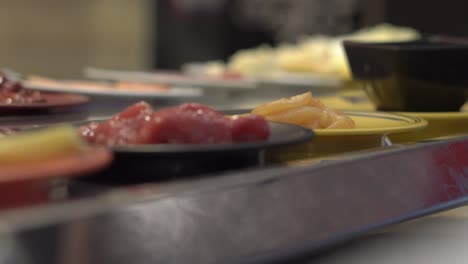 transportador de alimentos. cafetería de estilo asiático con comida moviéndose en un transportador en pequeños platos. concepto de desperdicio de alimentos. desperdicio concepto de comer en exceso