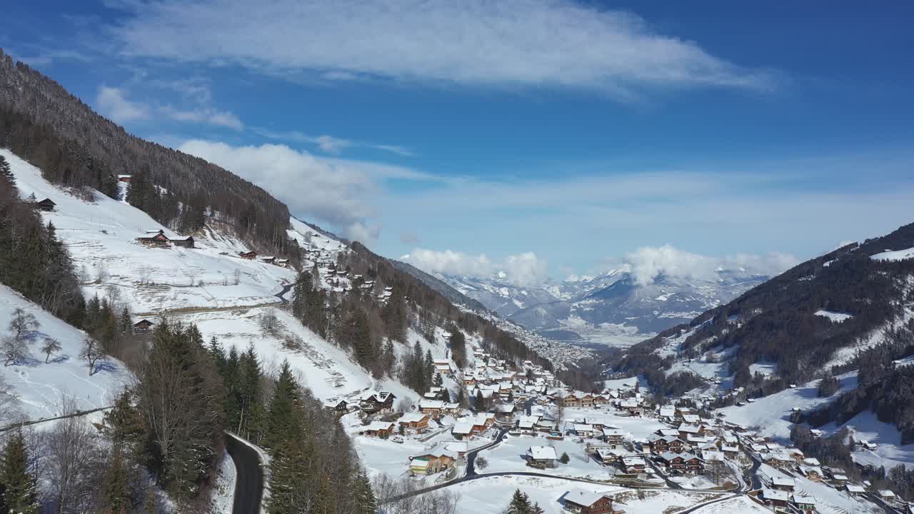 increíble vuelo de drones de un impresionante valle alpino, pueblo y picos montañosos cubiertos de nieve en champery, suiza