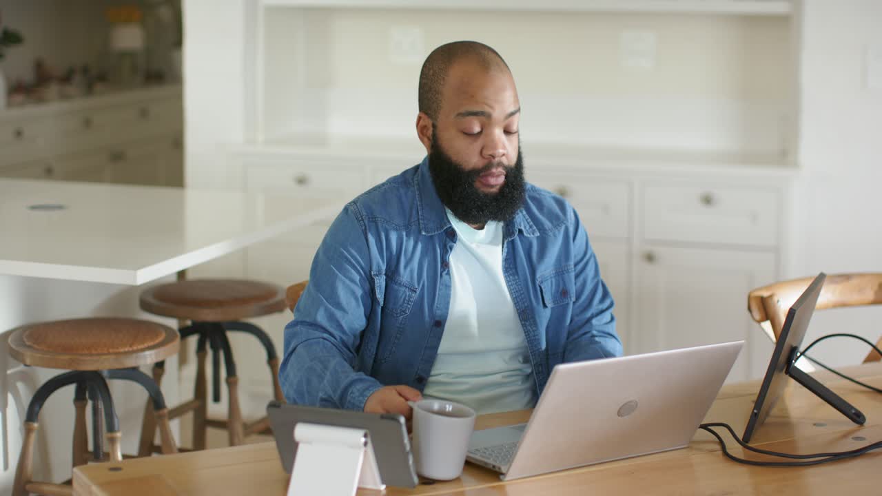 Man sipping mug while scanning laptop, spotting surprise, leaning and typing on tablet for business