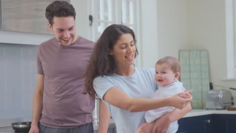 Amorosa-Familia-Transgénero-Con-Un-Bebé-En-Casa-En-La-Cocina-Con-Un-Hombre-Cocinando-Comida