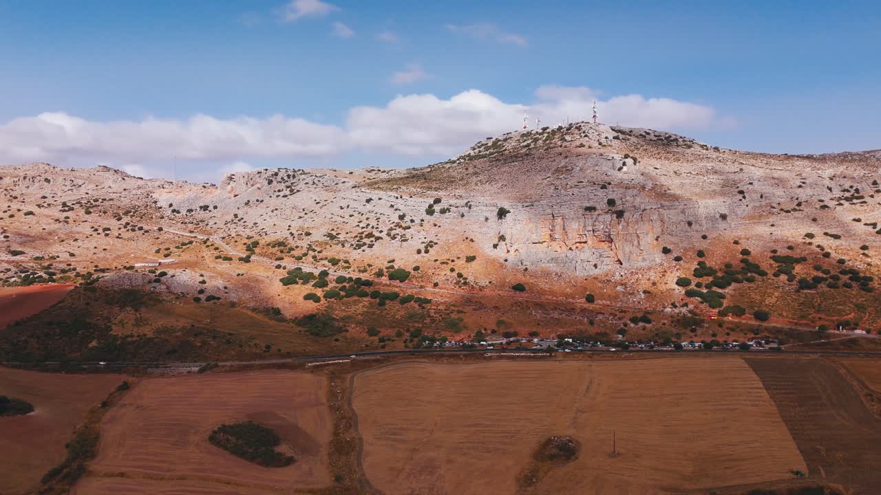 Ampia veduta di un altopiano roccioso sopra campi agricoli aridi.