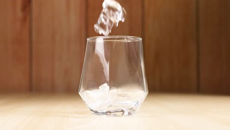 ice cubes falling into an empty glass