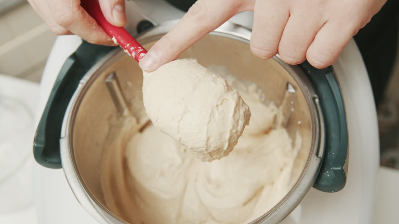 chef mezclando hummus dip con una cuchara en primer plano