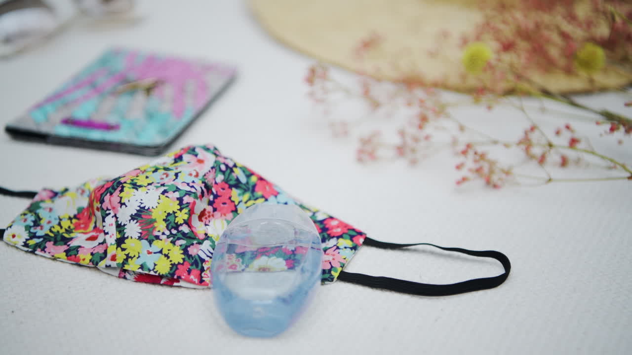 Floral Cloth Face Mask, Bottle Of Sanitizer, Passport, And Beautiful Lady's Bag On The Flat Lay - Feminine Travel Concept - selective focus